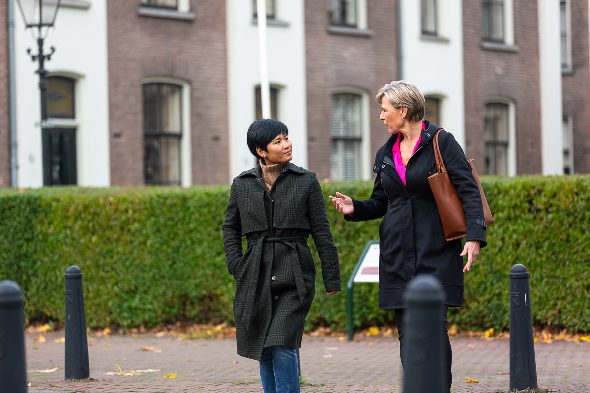 Twee vrouwen lopen buiten en praten met elkaar