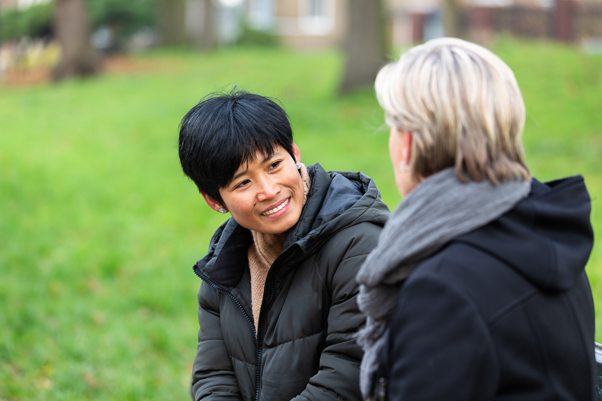 Twee vrouwen zitten buiten te praten